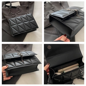 Detail of black quilted shoulder bag featuring metal chain and stylish long fringe