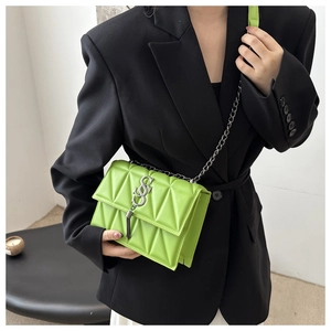 Detail of fruit green quilted shoulder bag with silver S-lock and chain strap on model