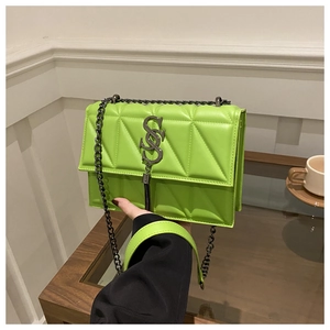 Detail of neon green quilted leather crossbody bag with metallic chain and logo