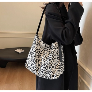 Chic leopard print canvas tote bag styled with a black blazer for a retro look