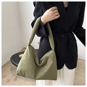 Borsa hobo verde minimalista con trama morbida e grande capacità indossata dal modello