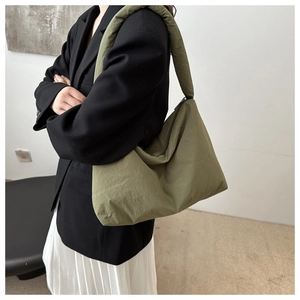 Dettaglio della borsa tote in nylon imbottito verde oliva con tracolla spessa e zip di chiusura