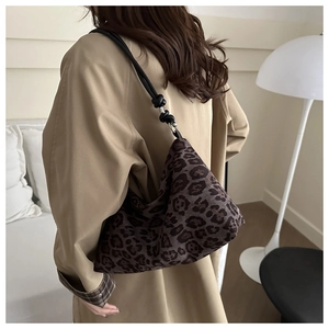 Detail showing retro leopard print tote bag with black knotted straps on model's shoulder