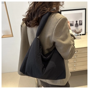 Modella che indossa una grande borsa a tracolla nera minimalista mostrando dimensioni
