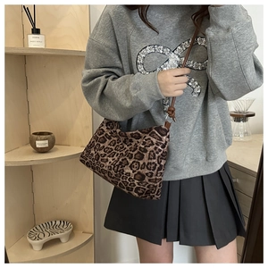 Detail of trendy leopard print shoulder bag with brown strap in a minimalist setting