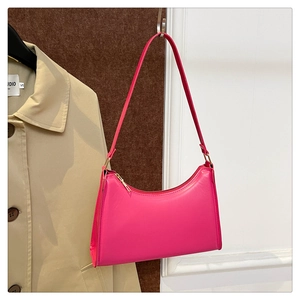 Close-up of pink faux leather baguette bag with metal zipper and stylish strap