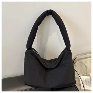 Dettaglio della borsa tote trapuntata nera con tracolla imbottita e zip in metallo lucido