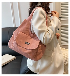 Pink corduroy tote bag showing large front flap pocket and soft ribbed texture detail