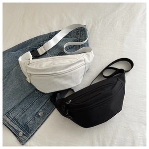 Minimalist nylon crossbody waist bag in black and white checkered pattern on denim jacket