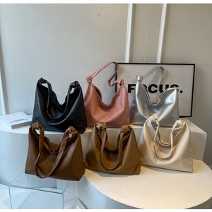 Large soft leather hobo tote bag in six colors displayed on a modern white pedestal