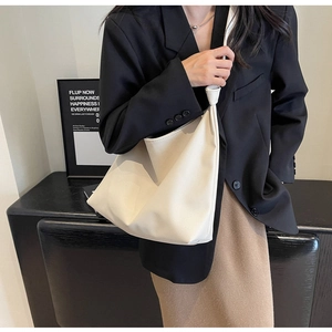 Close-up of cream white lychee texture leather shoulder bag with stylish knot detail