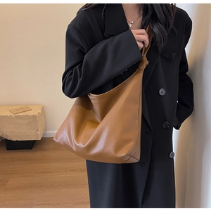 Detailed view of brown textured leather hobo bag featuring a unique knotted shoulder strap