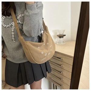 Detailed texture of khaki corduroy half-moon bag with white letter print and wide strap