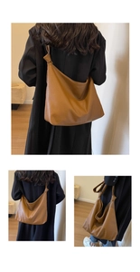 Detail of soft brown leather tote bag with lychee texture and knot buckle shoulder strap