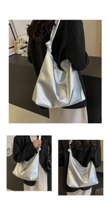 Detail of silver metallic tote bag featuring a unique knotted shoulder strap and soft texture
