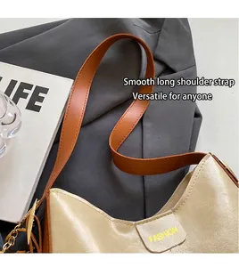 Détail du sac hobo beige avec logo Fashion, bandoulière marron et chaîne en métal doré