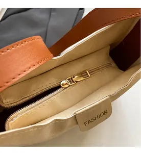 Vue détaillée de la fermeture éclair dorée et de la doublure beige avec étiquette en cuir