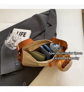 Vue détaillée du sac bandoulière en toile beige avec cuir brun et grand intérieur