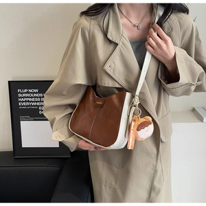 Sac bandoulière bicolore demi-lune marron et crème avec un pendentif ours mignon
