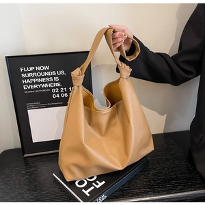 Brown lychee grain hobo tote bag with a soft silhouette and stylish knotted shoulder strap
