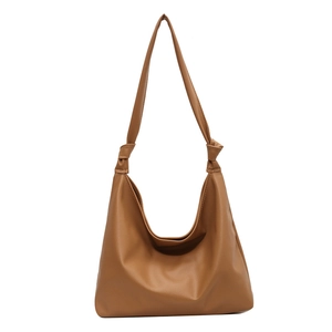 Retro caramel brown hobo shoulder bag with stylish knotted strap detail on white background