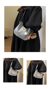 Sac sous le bras croissant argenté avec finition métallique sur un manteau noir