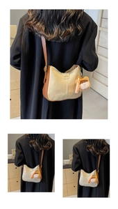 Détail du sac hobo bandoulière beige et marron avec pendentif poupée en peluche