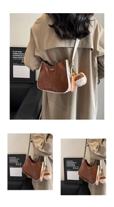 Détail du sac bandoulière bicolore marron et beige avec texte fashion et porte-clés