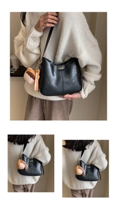 Détail du sac bandoulière en cuir noir avec imprimé FASHION et breloque ours