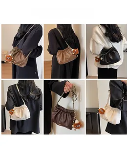 Detail view of ruched cloud bags in four colors with chain straps and plush charms