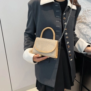 Sac à main chic beige avec strass et chaîne en métal porté par un mannequin en blazer