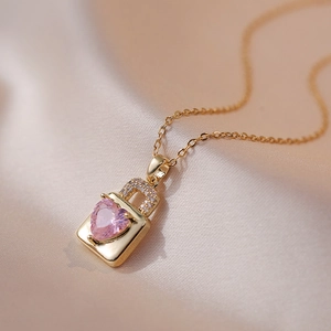 Collier cadenas doré avec pendentif cœur en zircon rose sur tissu de soie champagne chic