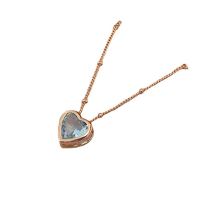 Collier cœur en or rose avec pierre bleu clair facettée sur une chaîne à billes fine