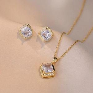 Elegant gold-plated square zircon necklace and earrings set on champagne silk fabric