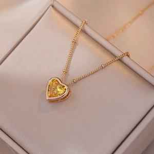 Elegant gold chain necklace with a heart-shaped yellow zircon pendant on a jewelry box