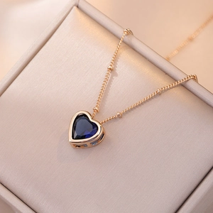 Macro d'un pendentif cœur en or rose avec zircon bleu dans une boîte à bijoux