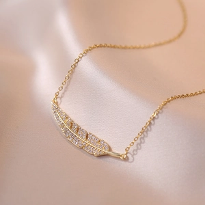 Collier élégant avec pendentif feuille dorée et cristaux sur soie champagne
