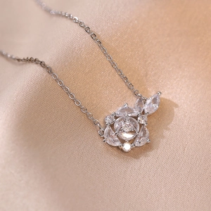 Elegant silver flower cluster necklace with sparkling zircon crystals on silk background