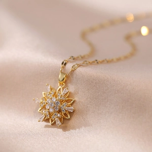 Golden snowflake necklace with sparkling zircon rotating pendant on satin background