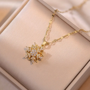 Golden rotating snowflake pendant necklace with cubic zirconia and flat scale chain