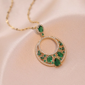 Macro di collana dorata con pietre di zircone verde smeraldo e pendente tondo traforato