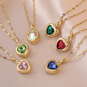 Elegant gold heart necklaces with six colored gems displayed on soft pink silk fabric