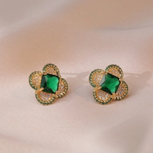 Golden clover stud earrings with emerald green zircon and pave crystals on silk