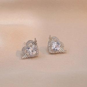 Elegante herzförmige Engelsflügel-Ohrringe mit Zirkonia-Steinen auf champagnerfarbener Seide