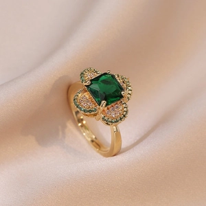 Anello di lusso con smeraldo taglio quadrato e foglie pavé su seta color champagne