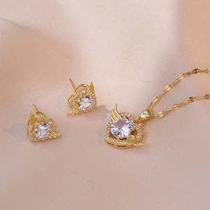Goldenes Engelsflügel Herz Schmuckset mit Halskette und Ohrsteckern auf rosa Seide
