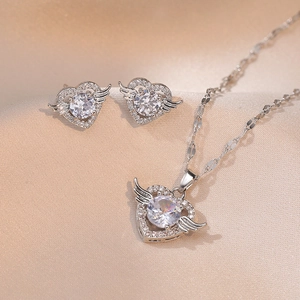 Elegantes Engelshaut-Herz Schmuckset mit Halskette und Ohrsteckern auf Seide