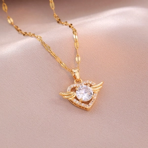 Detailansicht der Herz-Halskette mit goldenen Flügeln und Kristall auf rosa Seide