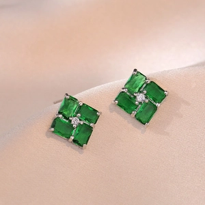 Elegant emerald green square stud earrings with crystal center on champagne silk