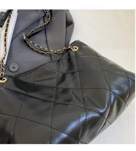 Close-up of black quilted PU leather shoulder bag with elegant gold chain strap